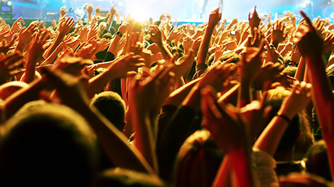 Crowd of people with their hands up singing to the band on stage at Argosy Casino Alton.