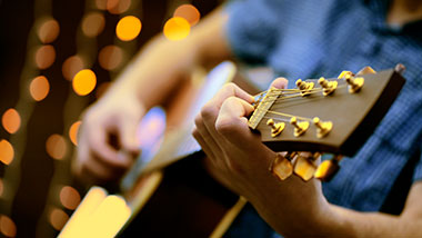Man playing guitar with live, local entertainment bands at Argosy Casino Alton.